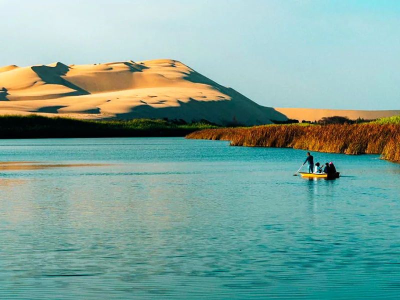Paisaje cinematográfico de la Laguna Costa Rica en Pisco, un oasis virgen y escondido entre dunas ideal para tours privados en bote y kayak lejos del turismo masivo.