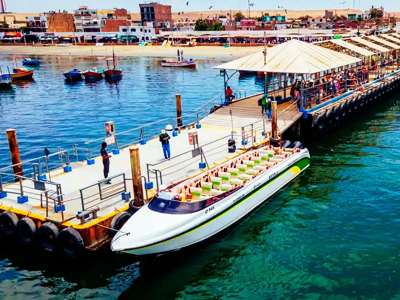 Deslizador turístico moderno esperando pasajeros en el Muelle El Chaco de Paracas