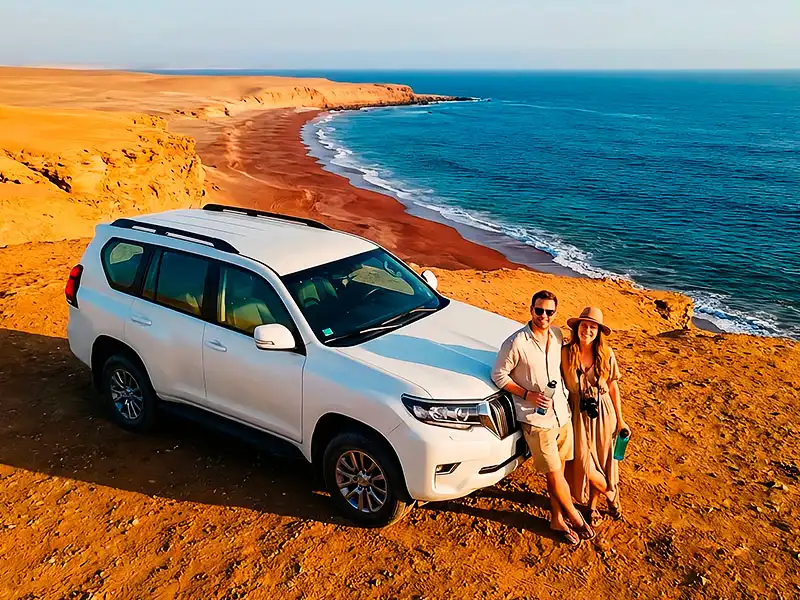 Pareja disfrutando de un tour privado en la Reserva Nacional de Paracas en Playa Roja sin multitudes, servicio exclusivo en auto particular.