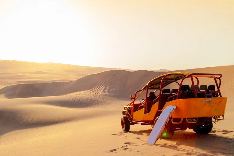 Carro arenero tubular recorriendo las dunas de California en Paracas al atardecer