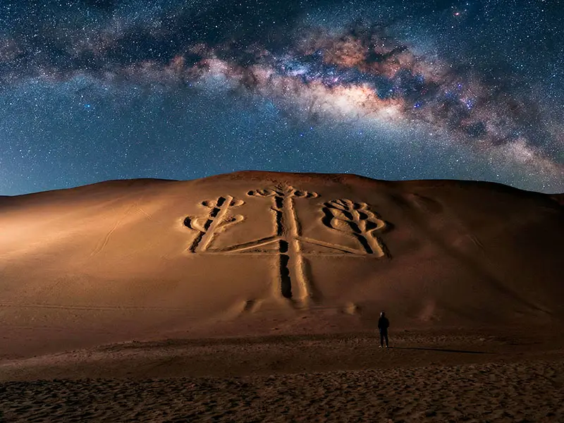 Geoglifo El Candelabro bajo un cielo estrellado en Paracas. Turismo de misterio.