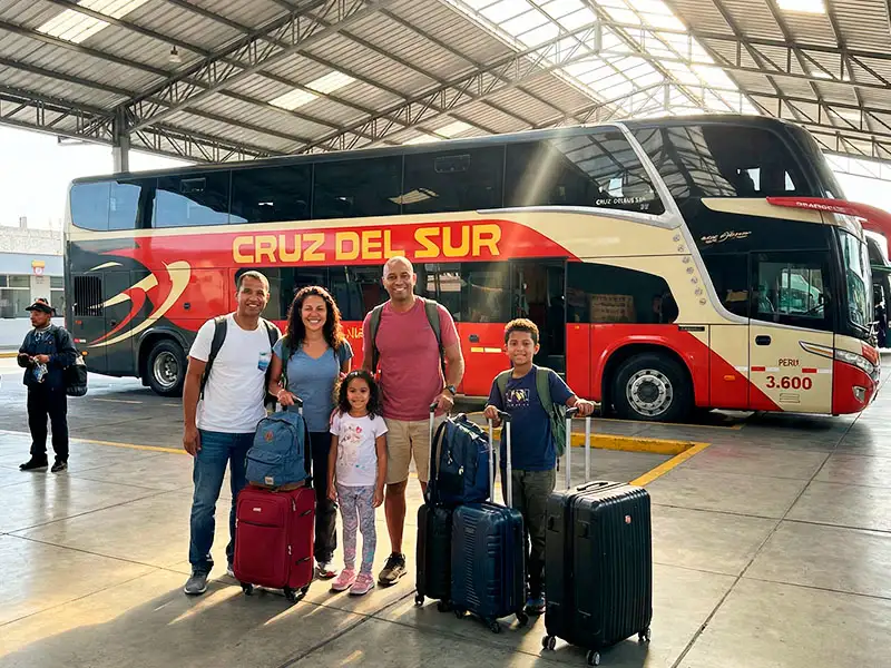 Familia con equipaje haciendo fila para abordar un bus de la empresa Cruz del Sur en Lima, una de las opciones populares sobre cómo ir de Lima a Paracas