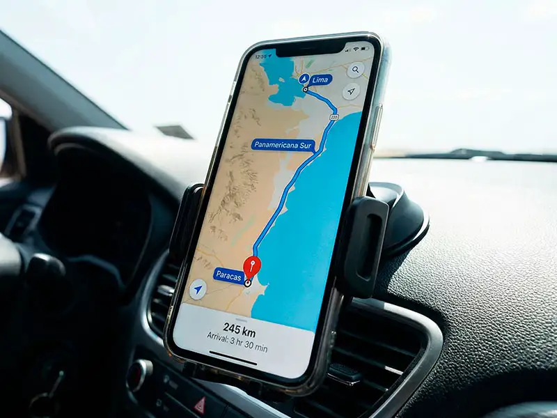 Primer plano de una pantalla de celular con GPS mostrando el mapa de la ruta por la Panamericana Sur, indicando cómo ir de Lima a Paracas
