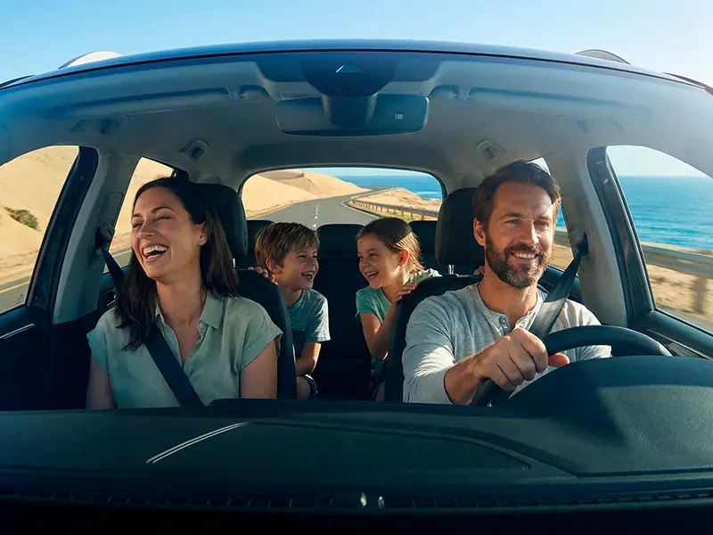 Familia feliz viajando en auto propio por la carretera costera, una de las formas de cómo ir de Lima a Paracas