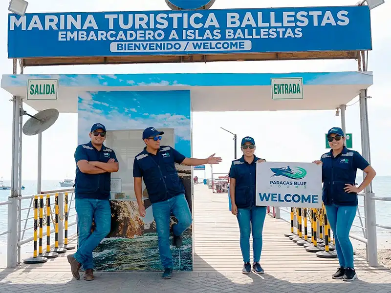 Anfitriones de Paracas Blue Tours esperando a los pasajeros en el ingreso principal de la Marina Turística Ballestas.