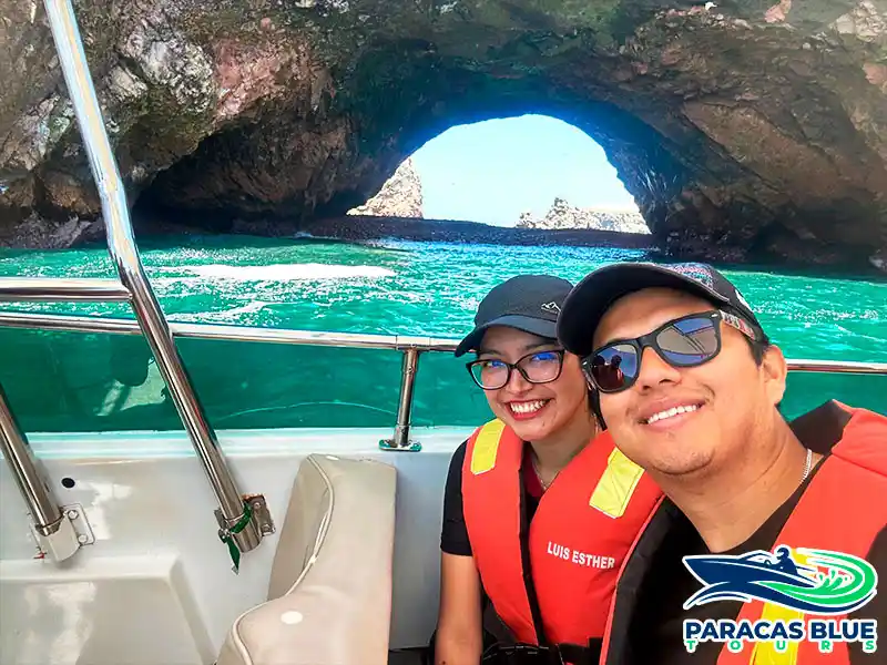 Pareja durante el tour a las Islas Ballestas en Paracas frente al arco natural sobre el mar