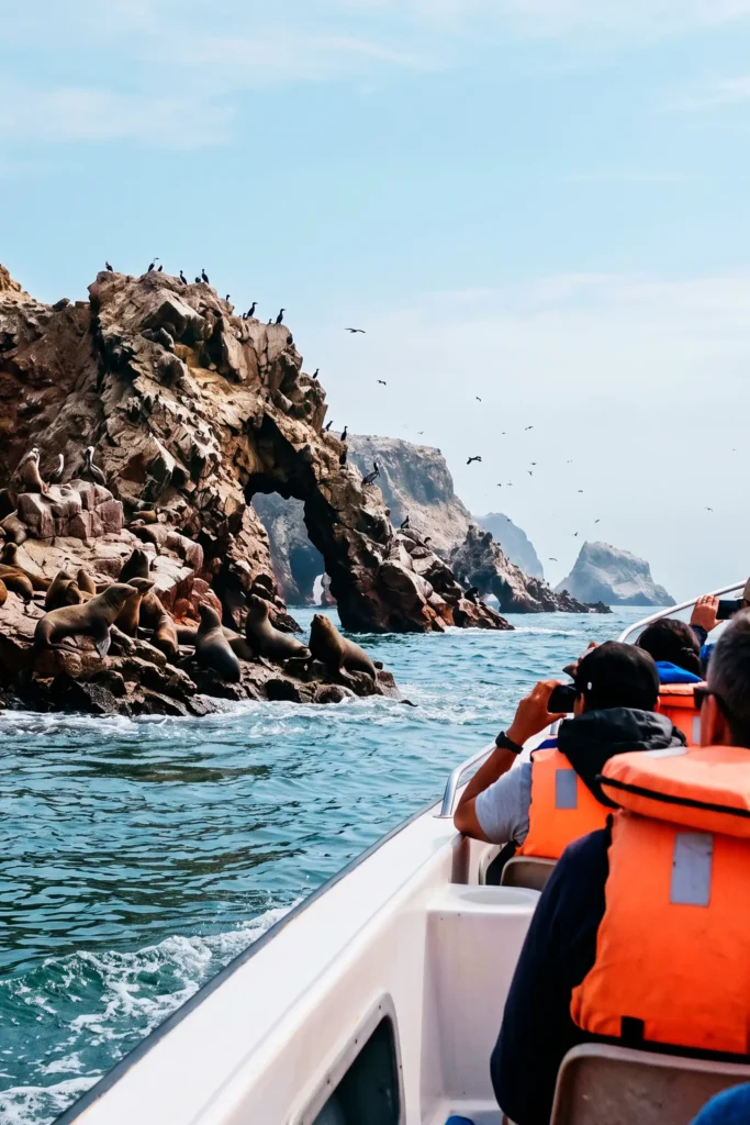 Lancha turística navegando entre las formaciones rocosas de las Islas Ballestas en Paracas